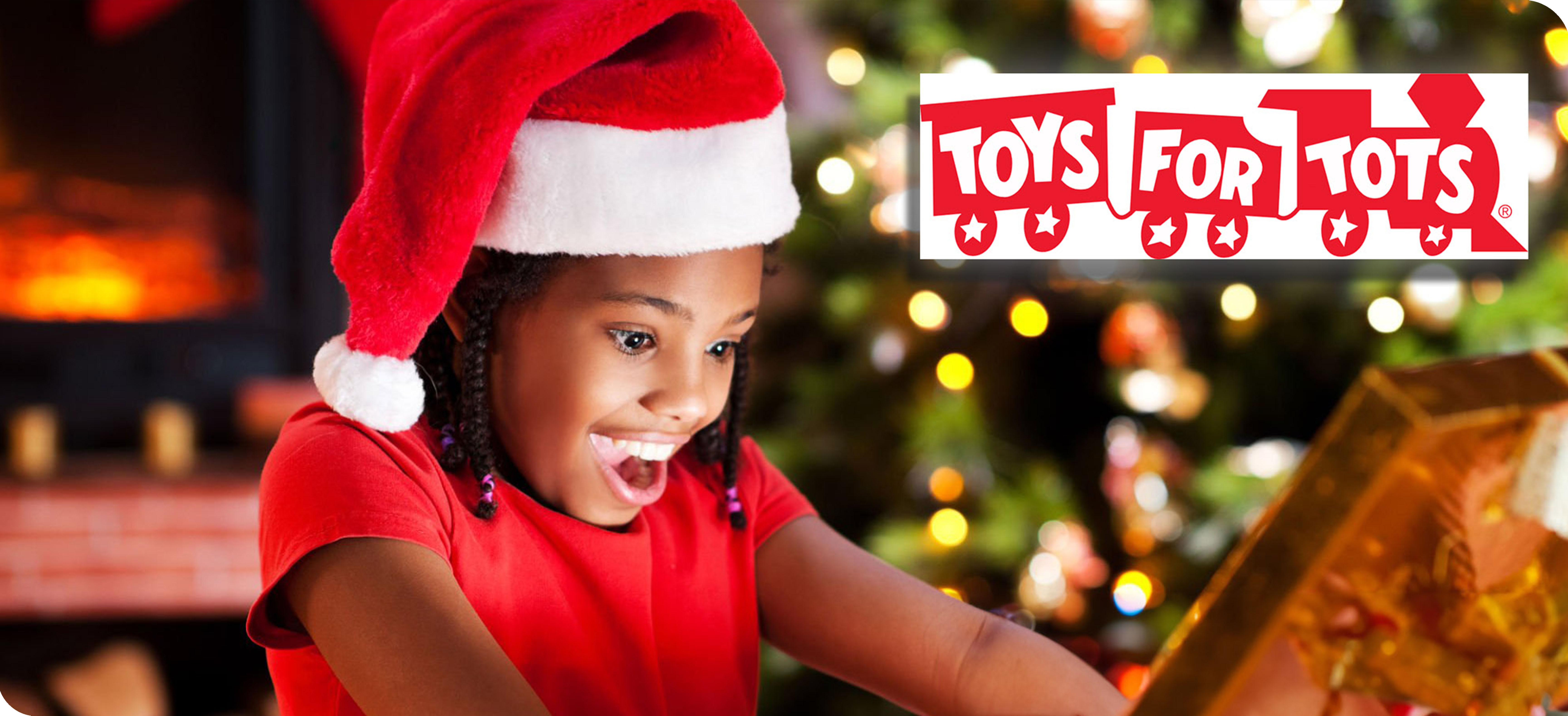 Young girl opening Christmas gift from Toys for Tots.